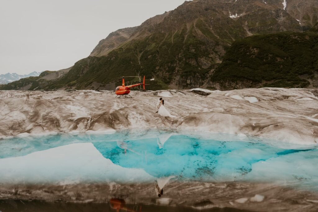 A couple stands on a glacier together.